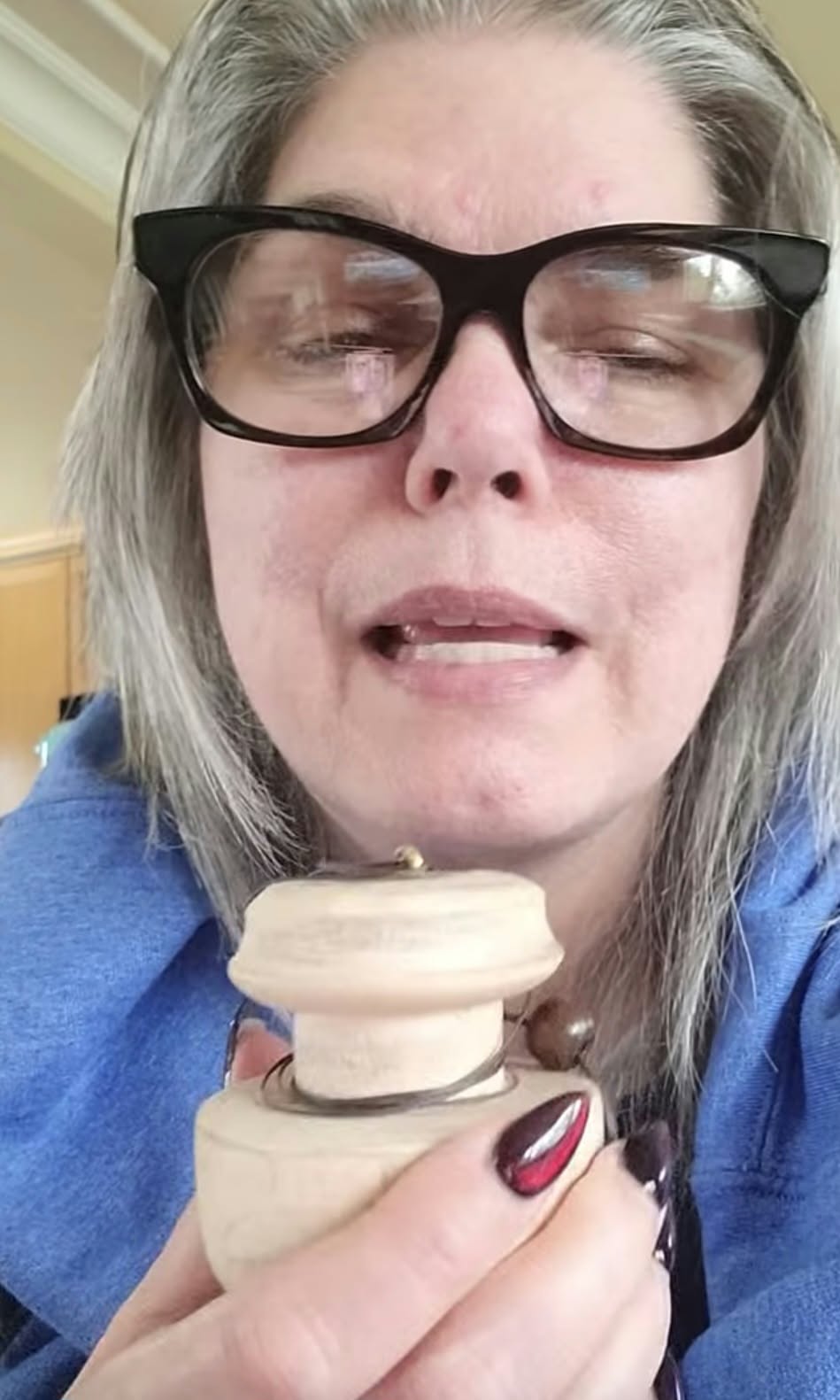 Lady holding pendulum, sharing her thoughts on using it. Click to hear her thoughts on facebook.